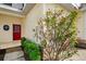 Close-up of the front door and garden featuring a vibrant red door at 1156 Jonah Dr, North Port, FL 34289