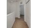 Hallway with neutral carpeting leading to an open door and a closet with sliding doors at 1156 Jonah Dr, North Port, FL 34289