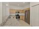 Kitchen boasts granite counters, light wood cabinets, and stainless steel appliances, including microwave and refrigerator at 1156 Jonah Dr, North Port, FL 34289