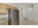 Kitchen view, featuring a stainless steel refrigerator and granite countertop with light wood cabinets at 1156 Jonah Dr, North Port, FL 34289