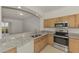 Kitchen featuring granite countertops, stainless steel appliances, light wood cabinets, with adjacent view of the lanai at 1156 Jonah Dr, North Port, FL 34289