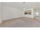 Spacious living room with carpet flooring adjacent to the kitchen, perfect for entertaining and everyday living at 1156 Jonah Dr, North Port, FL 34289