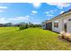 Large backyard with green grass, a manicured hedge, landscaping and views of other houses at 17336 Sandpearl Rd, Venice, FL 34293
