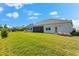 Lush backyard with green grass, a manicured hedge for privacy, and the rear of the home at 17336 Sandpearl Rd, Venice, FL 34293