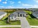 Beautiful one-story home with a paved driveway, lush landscaping, and a neutral color palette at 17336 Sandpearl Rd, Venice, FL 34293