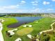Scenic aerial view of the golf course, lake and surrounding landscape at 17336 Sandpearl Rd, Venice, FL 34293