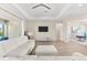 Open living room boasts tray ceilings, a modern ceiling fan, and sliding glass doors for natural light at 17336 Sandpearl Rd, Venice, FL 34293