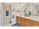 Bathroom with double sinks, natural wood cabinetry, and soft lighting at 1751 Nottingham Trl, Punta Gorda, FL 33980