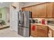 Bright kitchen area featuring stainless steel refrigerator and light wooden cabinets, adjacent to dining area at 1751 Nottingham Trl, Punta Gorda, FL 33980