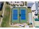 Aerial view of tennis courts beside well-maintained bocce ball courts, golf cart parking, and community buildings at 1751 Nottingham Trl, Punta Gorda, FL 33980