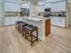Bright kitchen with granite countertops, stainless steel appliances, and island with bar stools at 18396 Laramie Ave, Port Charlotte, FL 33954