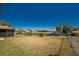 View of the large grassy backyard with canal view and chainlink fence separating the yard and the canal at 18584 Alphonse Cir, Port Charlotte, FL 33948