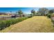 Expansive backyard with lush landscaping, a canal view, and a secure chain-link fence, and a boat lift in the background at 18584 Alphonse Cir, Port Charlotte, FL 33948