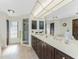 Spacious bathroom with dual sinks, a walk-in shower, neutral tile, and built-in cabinetry at 18584 Alphonse Cir, Port Charlotte, FL 33948