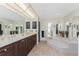 Large bathroom featuring dual vanities, a corner soaking tub, mirrors, and natural light at 18584 Alphonse Cir, Port Charlotte, FL 33948