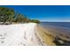 Scenic white sand beach with clear, shallow water, perfect for relaxing walks and enjoying the natural beauty at 18584 Alphonse Cir, Port Charlotte, FL 33948