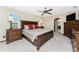 A primary bedroom featuring wood furniture, ceiling fan, and access to ensuite bathroom at 18584 Alphonse Cir, Port Charlotte, FL 33948