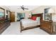 Spacious main bedroom featuring dark wood furniture, a ceiling fan and access to an outdoor space at 18584 Alphonse Cir, Port Charlotte, FL 33948