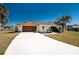 Charming home with a clean white driveway and mature landscaping at 18584 Alphonse Cir, Port Charlotte, FL 33948