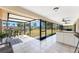 Screened lanai overlooking the backyard and canal with seating and a counter with cabinets at 18584 Alphonse Cir, Port Charlotte, FL 33948