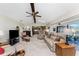 This living room features a ceiling fan, neutral carpet, skylight, and sliding glass doors to the enclosed lanai at 18584 Alphonse Cir, Port Charlotte, FL 33948