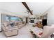 The open living room features a fireplace, skylight, ceiling fan and sliding glass doors to the enclosed lanai at 18584 Alphonse Cir, Port Charlotte, FL 33948
