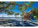 Beautiful waterfront playground featuring swings, slides, and imaginative play structures under a mature oak tree at 18584 Alphonse Cir, Port Charlotte, FL 33948