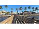 Scenic waterfront restaurant with palm trees, thatched roofs, and an inviting pier with American flags at 18584 Alphonse Cir, Port Charlotte, FL 33948