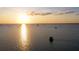 Sunset over the water, featuring sailboats scattered across the horizon and a small structure in the foreground at 18584 Alphonse Cir, Port Charlotte, FL 33948