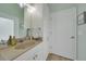 Well-lit bathroom with a single sink vanity, decorative mirror, and a door leading to additional space at 19023 Midway Blvd, Port Charlotte, FL 33948