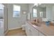 Bathroom featuring white cabinets, a shower, a commode, and a large mirror at 19023 Midway Blvd, Port Charlotte, FL 33948
