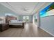 Bright bedroom features wood floors, tray ceilings, and a large window with a view at 19023 Midway Blvd, Port Charlotte, FL 33948