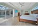 A bright bedroom with light tile flooring leads to a view of the pool area through sliding glass doors at 19023 Midway Blvd, Port Charlotte, FL 33948