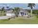 Charming single-story home with a well-manicured lawn, palm trees, and a colorful front door at 19023 Midway Blvd, Port Charlotte, FL 33948