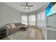 Living room featuring a gray sofa, white sheer curtains, a TV, and light hardwood floors at 19023 Midway Blvd, Port Charlotte, FL 33948