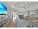 Spacious living room with light wood flooring, modern furnishings, and a large TV at 19023 Midway Blvd, Port Charlotte, FL 33948