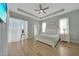 Spacious main bedroom boasts tray ceilings, light-filled windows, and a serene ambiance with a ceiling fan at 19023 Midway Blvd, Port Charlotte, FL 33948