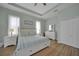 Bright main bedroom features wood-look floors, a ceiling fan, and two windows with curtains for a cozy space at 19023 Midway Blvd, Port Charlotte, FL 33948
