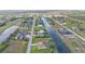 An aerial view of a waterfront neighborhood, displaying homes, canals, and nearby recreational area with green spaces at 235 Tournament Rd, Rotonda West, FL 33947