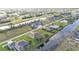An overhead view shows homes nestled along a canal, enhanced by a nearby green space, and a community layout at 235 Tournament Rd, Rotonda West, FL 33947