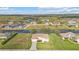 Aerial view of a property with water views, landscaping, and surrounding homes in a neighborhood at 235 Tournament Rd, Rotonda West, FL 33947