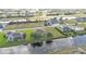 A neighborhood aerial view featuring canal-front properties, showcasing the community design and surrounding landscape and greenery at 235 Tournament Rd, Rotonda West, FL 33947