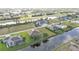 An aerial perspective captures the layout of homes alongside a waterway, with views of a green space and the surrounding community at 235 Tournament Rd, Rotonda West, FL 33947