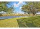 Spacious backyard with verdant grass and tranquil water view offering privacy and relaxation at 235 Tournament Rd, Rotonda West, FL 33947