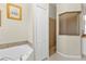 Bathroom featuring a large tub and separate shower with tiled walls and a glass door at 235 Tournament Rd, Rotonda West, FL 33947