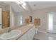 Primary bathroom featuring a double vanity and a door to the lanai at 235 Tournament Rd, Rotonda West, FL 33947