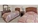 Cozy bedroom featuring two twin beds, wooden furniture, and a calm, neutral color scheme at 235 Tournament Rd, Rotonda West, FL 33947