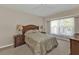 Cozy bedroom with a ceiling fan, plush bed, and bright natural light at 235 Tournament Rd, Rotonda West, FL 33947
