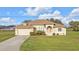 Well-maintained single-story home with attached garage and nicely landscaped front yard at 235 Tournament Rd, Rotonda West, FL 33947