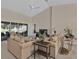 Open-concept living room featuring neutral-toned furniture, vaulted ceilings, and sliding glass doors to the backyard at 235 Tournament Rd, Rotonda West, FL 33947
